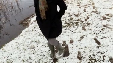 Kadınlar kışın karda lastik botlarla üşütürler.