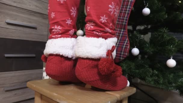 Female Legs Knitted Socks Wooden Chair Christmas Tree — Stockvideo