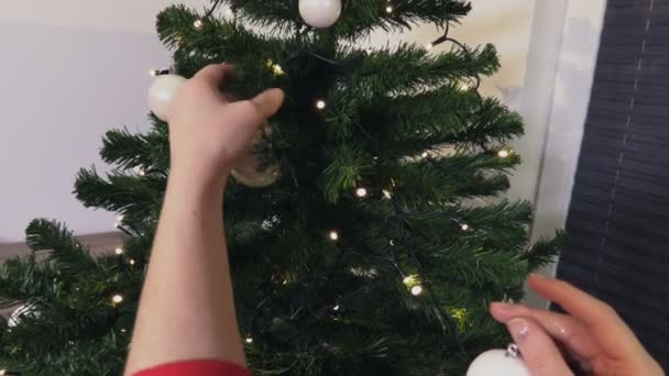 圣诞睡衣中的女人把圣诞树装饰得紧贴着 — 图库视频影像