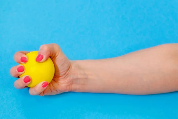 Woman squeezing yellow stress ball
