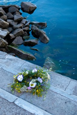 Bir büyük güzel buket çiçegi çelenk, yeşil çim Dinyeper Nehri arka planı gri taş merdiven üzerinde yatıyor ve taş su kenarında akşam Ivan Kupala'nın tatil