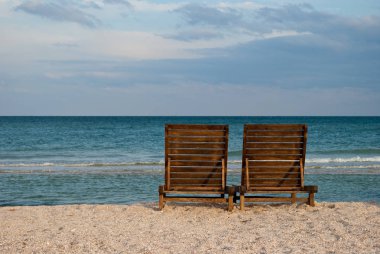 iki ahşap şezlong mavi deniz sahil su mavi gökyüzü deniz dalga güzel sahilde kahverengi manzara yaz tatil plaj kum hafta sonu dinlenme