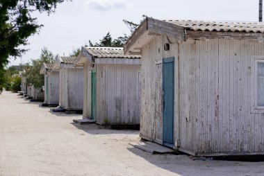 Bir satır, tek katlı, retro, vintage, eski bir ev, yaz parlak güneşli bir günde, kum, yeşil ağaçlar yoldan birkaç ahşap evler