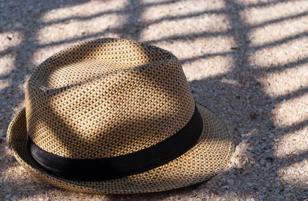 一顶棕色草帽躺在沙滩上 在夏日休息的阴凉处投下阴影 — 图库照片