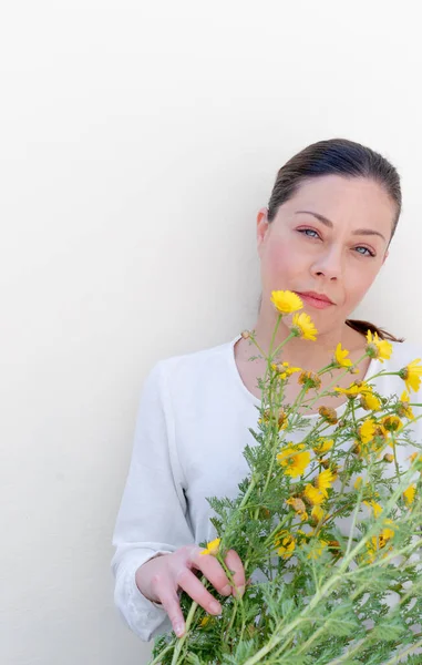 Beyaz Arka Planda Kır Çiçekleri Olan Genç Bir Kadın — Stok fotoğraf