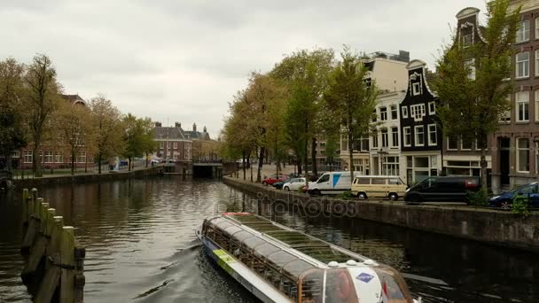 Amsterdam Netherlands - May 2017. A tourist boat sails through the Amsterdam canal — Stock Video