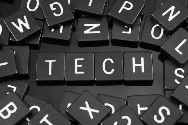 Zwarte letter tegels spelling van het woord "tech" — Stockfoto