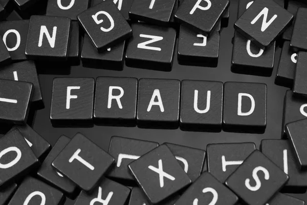 Black letter tiles spelling the word "fraud" — Stock Photo, Image