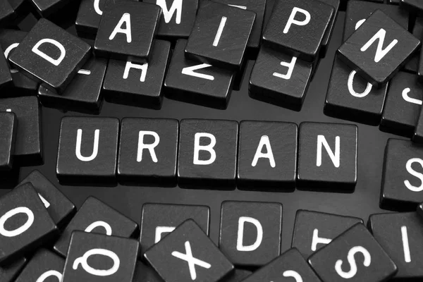 Azulejos de letras negras que deletrean la palabra "urbano " — Foto de Stock