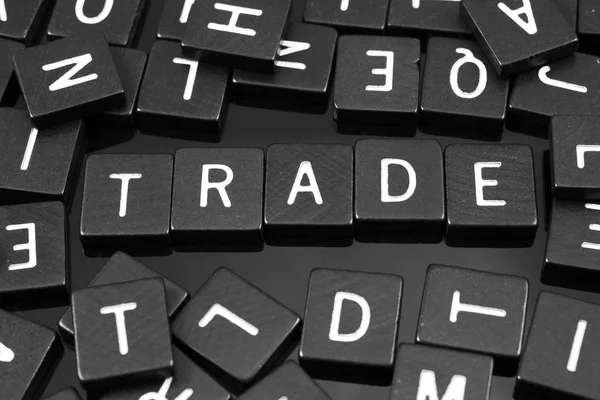 Black letter tiles spelling the word "trade" — Stock Photo, Image
