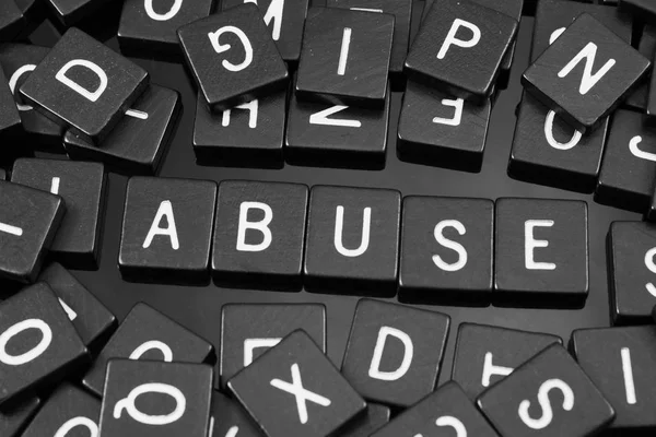 Azulejos de letras negras deletreando la palabra "abuso " — Foto de Stock