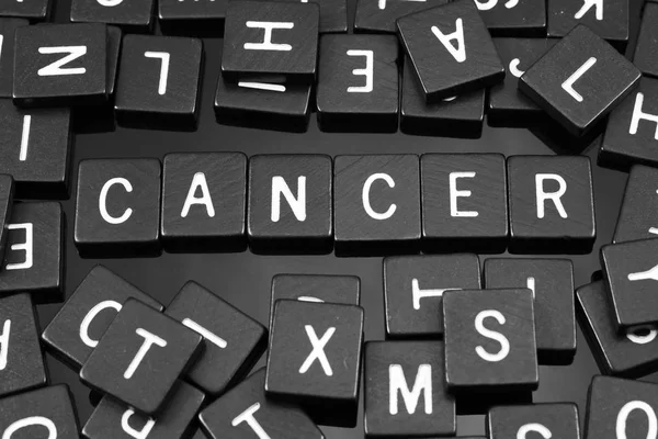 Azulejos de letras negras que deletrean la palabra "cáncer " — Foto de Stock