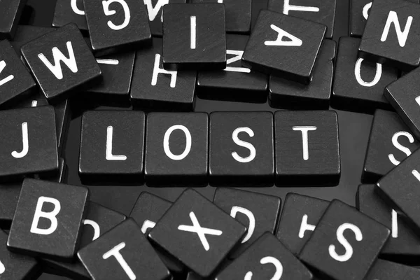Azulejos de letras negras que deletrean la palabra "perdido " — Foto de Stock