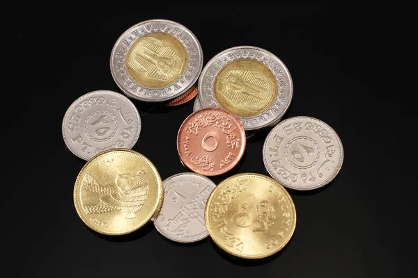 Surtido de monedas egipcias sobre un fondo negro — Foto de Stock