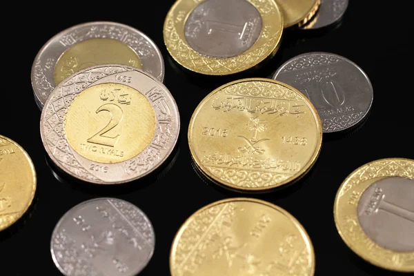 Verschiedene saudi-arabische Münzen auf schwarzem Hintergrund — Stockfoto