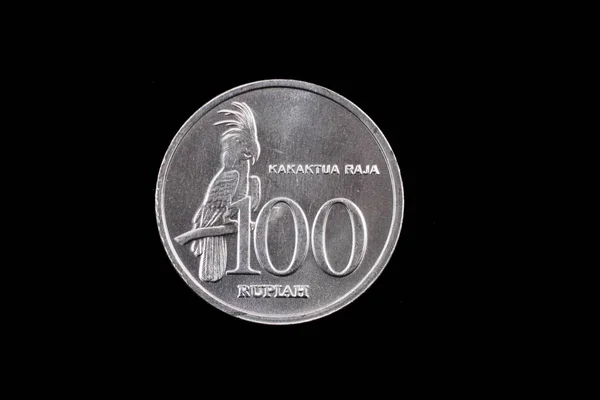 Indonesiska 100 Rupiah mynt som närbild på svart — Stockfoto