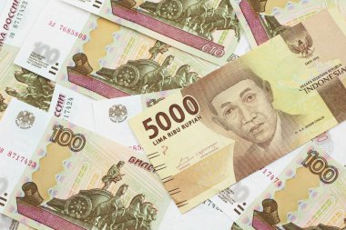 Bir portakal, beş bin Endonezya rupia banknotu içinde Rusça yüz ruble banknot, makroyla kaplanmış.