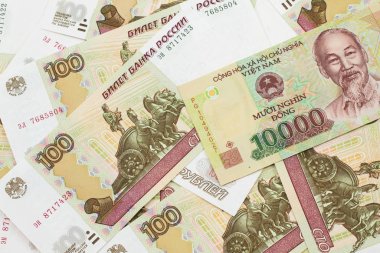 Rusça yüz ruble 'lik makro banknotların arka planında on bin dong' luk Vietnam banknotunun yakın plan görüntüsü.