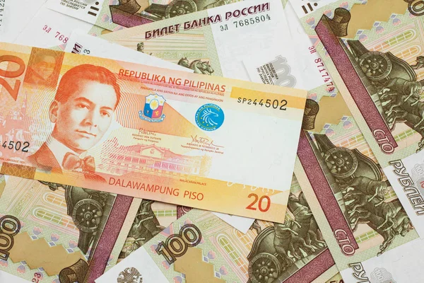 フィリピンからのオレンジの20のピソ銀行券ロシアの100ルーブル紙幣マクロで閉じます — ストック写真