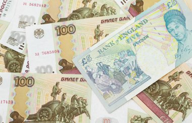 Birleşik Krallık 'tan gelen çok renkli beş sterlinlik banknotun yakın plan fotoğrafı makro Rusça yüz ruble banknotlar halinde.