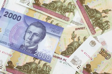 Şili 'den gelen iki bin pezoluk mor banknotun yakın plan görüntüsü makro banknotlar halinde yüz ruble değerinde bir Rus yatağı üzerinde.