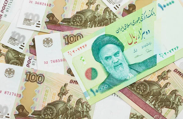 İran 'dan gelen yeşil on bin Riyal banknotun makro görüntüsü. Rus 100 rublelik banknotlar. Yakın plan.