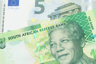 Güney Afrika 'dan gelen yeşil bir onluk banknot Avrupa Birliği' nin Avro Bölgesi 'nden gelen renkli beş avroluk banknotla makroyu kapatıyor.