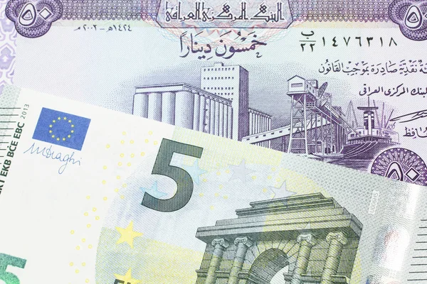 来自伊拉克的50第纳尔紫色钞票与来自欧洲中央银行的5欧元钞票接近 — 图库照片