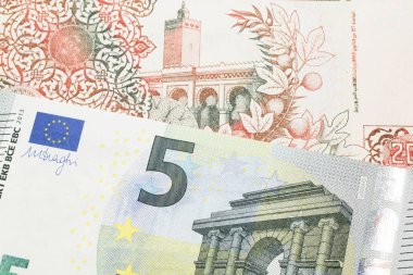 Bej rengi, 200 Cezayir dinarı faturası. Kırmızı, Avrupa Birliği 5 Euro 'luk banknot. Makro olarak yakın plan.