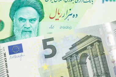 Yeşil İran 'a ait on bin riyal banknotun yakın plan görüntüsü. Üzerinde Fransa' dan gelen mavi ve yeşil beş avroluk makro banknot var.