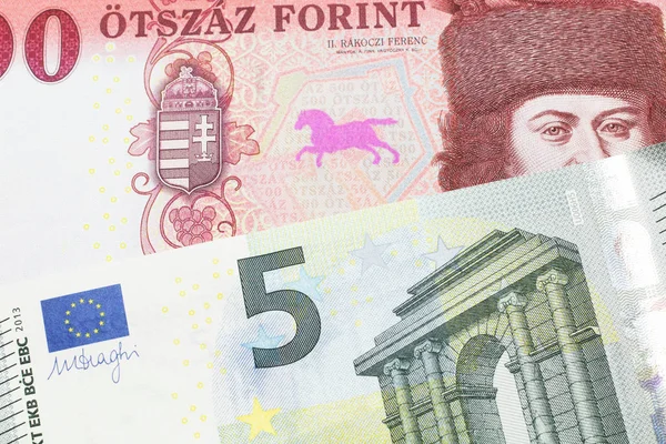 一张红色的 一百匈牙利福林钞票的特写镜头 旁边是德国的一张蓝色和绿色的5欧元宏观钞票 — 图库照片