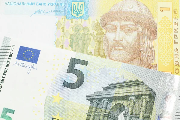 Avrupa 'nın beş avroluk yakın plan görüntüsü. Sarı ve mavi Ukraynalı. Ukraynalı bir Hryvnia banknotu makroda kapanıyor.