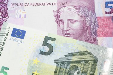 Üzerinde pembe ve mor beş Brezilya reais banknotu olan beş avroluk bir banknot. Makro çekimde..