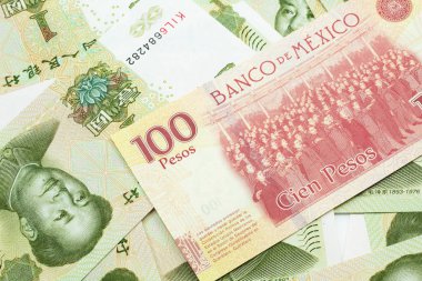100 Meksika pezosu ve Çin parası makroda bir Yuan banknotun yakın plan fotoğrafı.