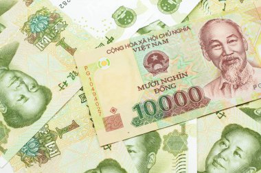 Bir Vietnamlı 'nın yakın plan görüntüsü on bin dong banknot Çin' in arka planında bir yuan makro banknotlar