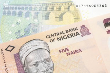 Nijerya 'dan 5 avroluk turuncu bir banknot ve makroda 5 avroluk bir Alman banknotu.