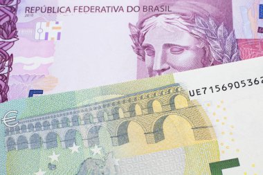 Üzerinde pembe ve mor beş Brezilya reais banknotu olan beş avroluk bir banknot. Makro çekimde..