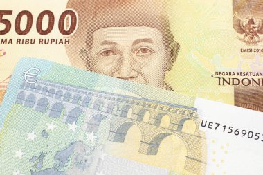 Turuncu bir 5 bin Endonezya rupia banknotu ve 5 avro. 