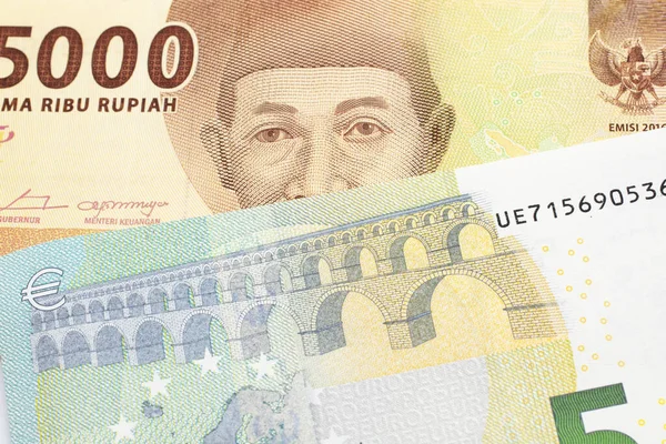Turuncu bir 5 bin Endonezya rupia banknotu ve 5 avro. 