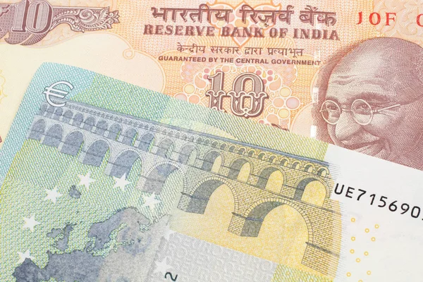 一张橙色的印度十卢比钞票 上面有一张法国寄来的蓝色和绿色的五欧元钞票 — 图库照片