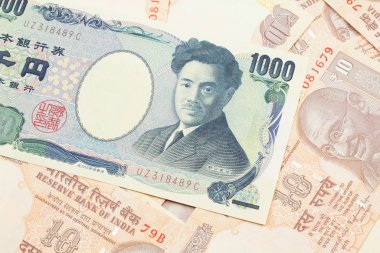 A one thousand Japanese yen bank note close up in macro with Indian ten rupee bank notes