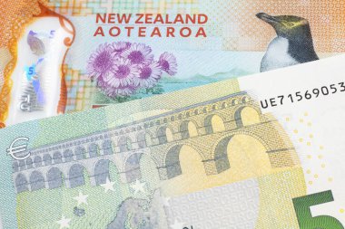 Yeni Zelanda 'dan beş dolarlık renkli bir banknot, makroda Avrupa Birliği' nden beş avroluk banknotla kapanıyor.