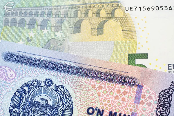 来自乌兹别克斯坦的1万索姆钞票 与来自欧盟欧元区的5欧元钞票以宏观方式接近 — 图库照片