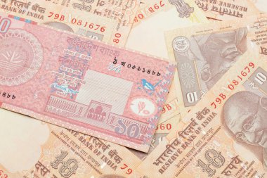 Bangladeş 'ten gelen kırmızı bir banknotun yakın plan görüntüsü. Hindistan' ın yatağında 10 rupilik makro banknotlar halinde.