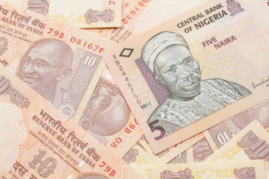 Şeftali renginde beş Nijeryalı naira banknotunun yakın plan görüntüsü Hindistan 'da 10 rupilik banknotlar halinde.