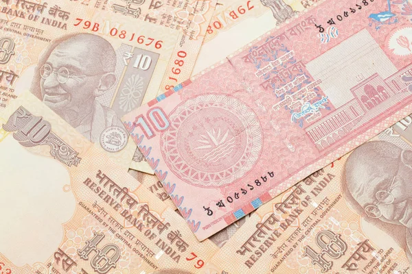 Bangladeş 'ten gelen kırmızı bir banknotun yakın plan görüntüsü. Hindistan' ın yatağında 10 rupilik makro banknotlar halinde.