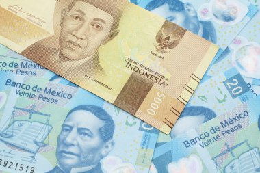 Bir portakal, beş bin Endonezya rupia banknotu ve içinde Meksika 20 pesosu olan makro banknotlar.