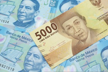 Bir portakal, beş bin Endonezya rupia banknotu ve içinde Meksika 20 pesosu olan makro banknotlar.