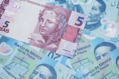 Brezilya 'dan gelen pembe bir 5 reais banknot Meksika pesolarının arka planında makroya yakın.