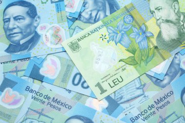 Meksika 20 pesosunun arka planında yeşil bir Romen banknotunun yakın plan görüntüsü